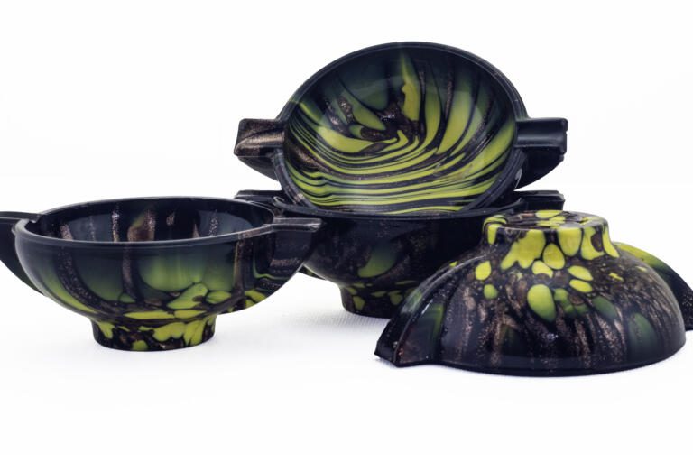 Set of four unused Venetian glass ashtrays with aventurine and monochrome décor in ebony black glass. Three ashtrays still retain the original Weil sticker.